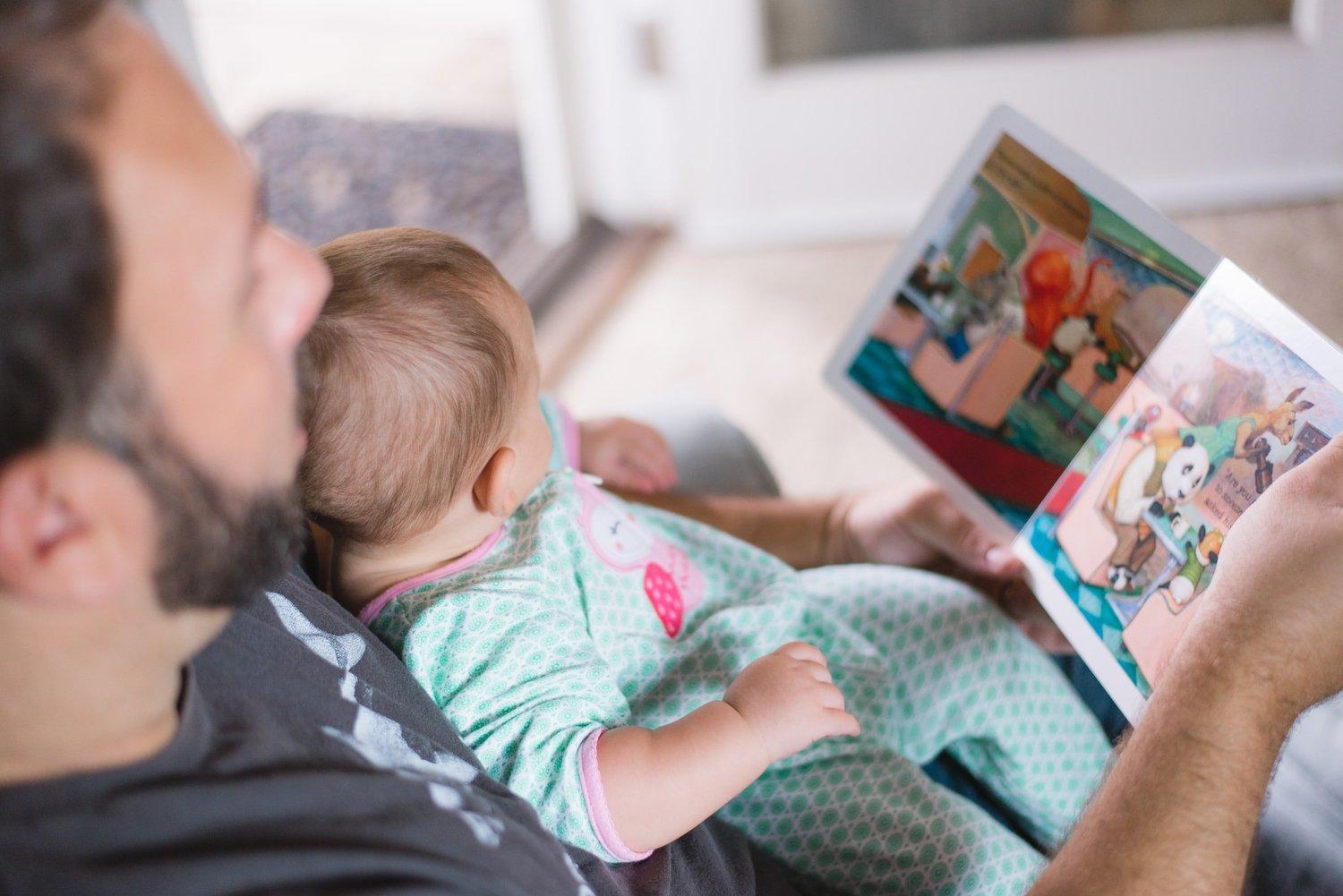 A parent and baby sharing a picture book together