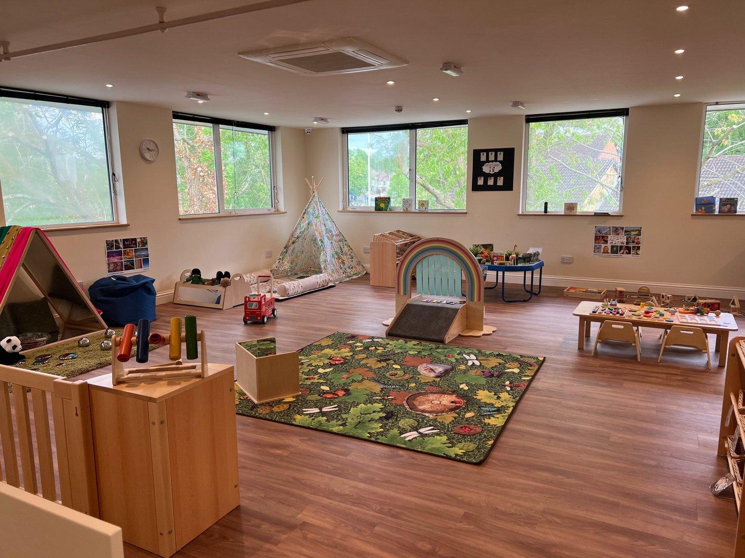 A bright nursery playroom with natural wood furniture