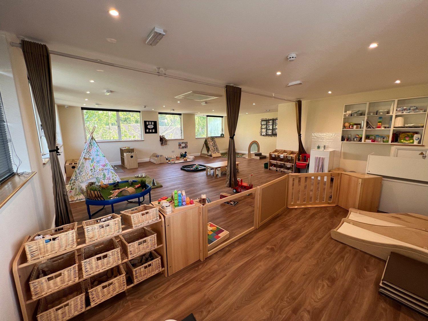A calm nursery room with a play tent and open shelves