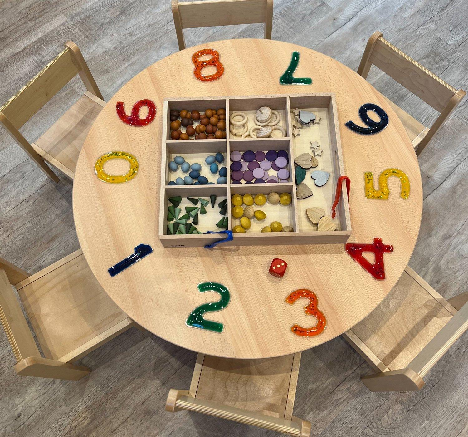 Colourful numbers and loose parts arranged for hands-on maths